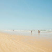 a large expanse of sand with the ocean in the background