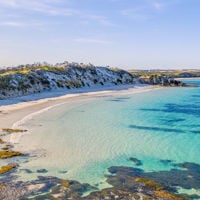 A sandy cove with shallow blue waters 